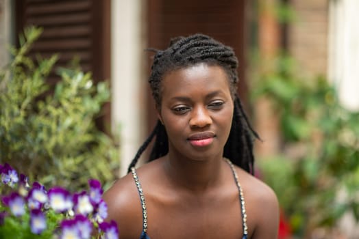 Happy young black woman smile. Stylish model. Braid dreadlock hairstyle. Joyful smiley African female in selective focus outdoors, fashion style, happiness concept. Outdoors.