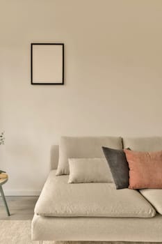 a living room with a couch, coffee table and plant in the corner on the left side of the room