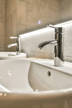 a bathroom sink with two faucets on the counter top and one faucet in the wall behind it