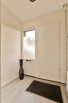 an empty room with white walls and wood flooring on the right, there is a black vase in the corner