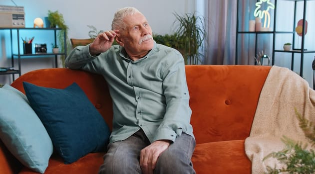 Sad lonely senior man sits at home looks pensive thinks over life concerns, bankruptcy, crisis, burnout. Elderly alone pensioner having problem, break up, depression, feeling bad annoyed. Retirement