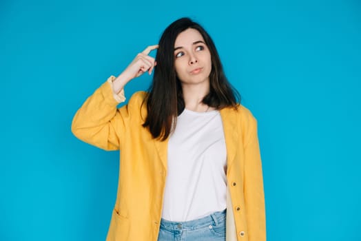 Intelligent Businesswoman in Thoughtful Pose Professional Woman with Pouted Lips and Scratching Head. Conceptual Image of a Clever and Mindful Business Lady. Perfect for Advertising. Blue Background