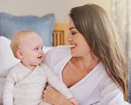 Mother, baby and smiling together or embracing daughter and having fun in the bedroom feeling happy. Parent, kid and mom bonding or carefree and excited together in the house or parenthood.
