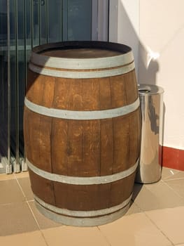 An old oak barrel stands at the entrance to a beer restaurant, shop, as an element of vintage design, vertical photo.