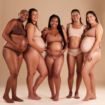 Pregnancy, beauty and portrait of friends in a studio for diversity, motherhood and prenatal wellness. Maternity, love and pregnant women showing their baby bump stomach together by beige background
