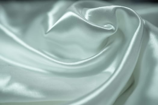 White satin fabric background with wavy soft folds for selling product. White Texture - light Wavy Glossy Silk Drapery. Shiny smooth fabric. Elegant background for design.