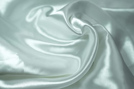 White satin fabric background with wavy soft folds for selling product. White Texture - light Wavy Glossy Silk Drapery. Shiny smooth fabric. Elegant background for design.