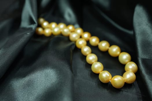 Golden South sea Pearl necklace on black satin background