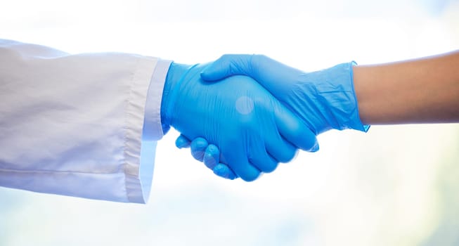 Partners in dental practice. two unrecognisable dentists wearing gloves and shaking hands