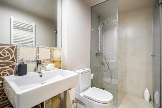 Interior of white bathroom in modern design, with shower zone and toilet.