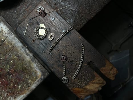 Old wood table for goldsmith with gold ring. Jeweler in Asia. Ancient and handmade jewelry work