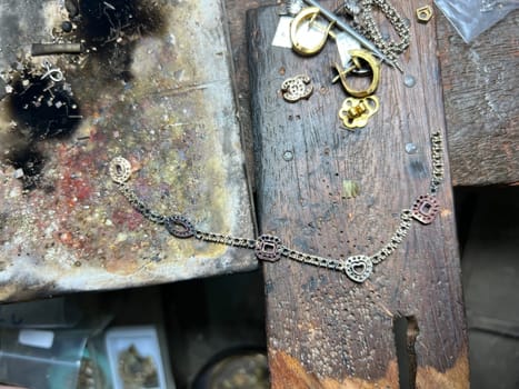 Old wood table for goldsmith with gold ring. Jeweler in Asia. Ancient and handmade jewelry work