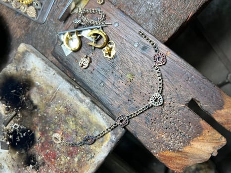Old wood table for goldsmith with gold ring. Jeweler in Asia. Ancient and handmade jewelry work