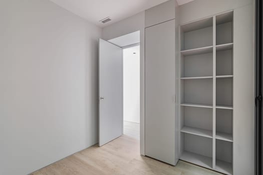 Interior of gray room with wardrobe and empty shelves. Refurbished apartment before settling of new tenants.