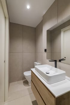 Interior of modern style bathroom in refurbished apartment. Shower zone, sink with black faucet and mirror