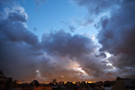 Blue sky at sunset twilight over city lights with heavy clouds.