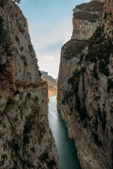 A high gorge of rocks and a mountain river. Deep narrow canyon along the river