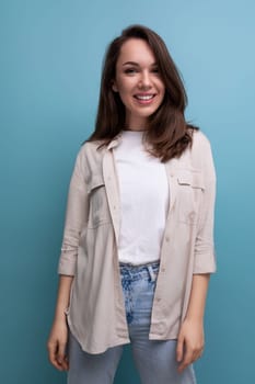 european young brunette female adult with chic well-groomed hair in a casual shirt on a blue background.