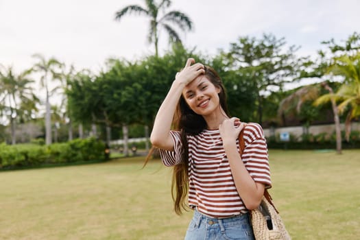 woman nature freedom lifestyle young enjoy bali summer fashion walk sun meadow hat exercise beautiful walking face park outdoor t-shirt smiling