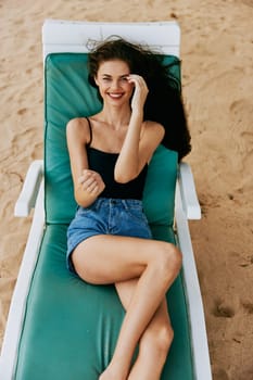 woman enjoy hair beach sunglasses beautiful blue sea sunbed resting hat resort ocean caucasian tropical swimwear smiling lifestyle sand lying holiday long