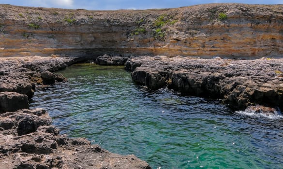 Karst cavity failure in the rocky shore, flooded by water in the eastern Crimea, Black Sea