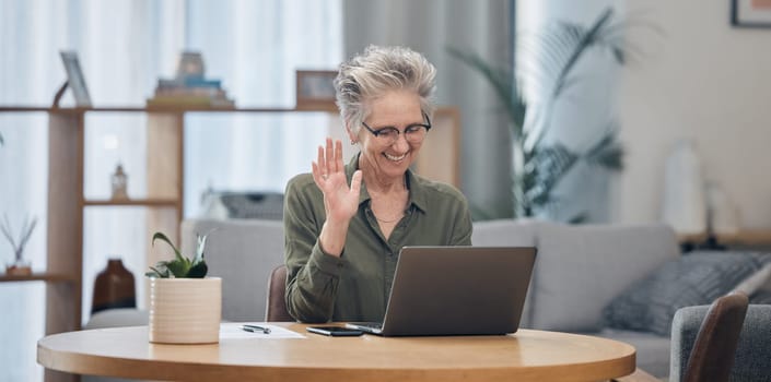 Laptop, video call and remote work with a senior woman at work in her home office for business communication. Computer, virtual meeting and planning with a mature female employee waving at her webcam.