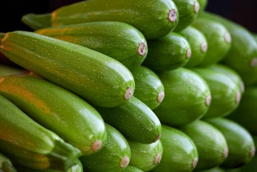Fresh cropped green Zucchini. Offer in the vegetable market, summer squash. Close-up of a showcase of young zucchini in the store