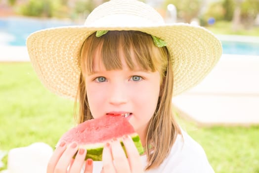 girl eating watermelon by the pool.