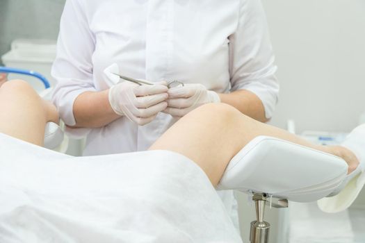 Professional gynecologist examining her female patient on a gynecological chair