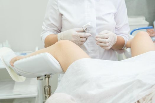 Professional gynecologist examining her female patient on a gynecological chair