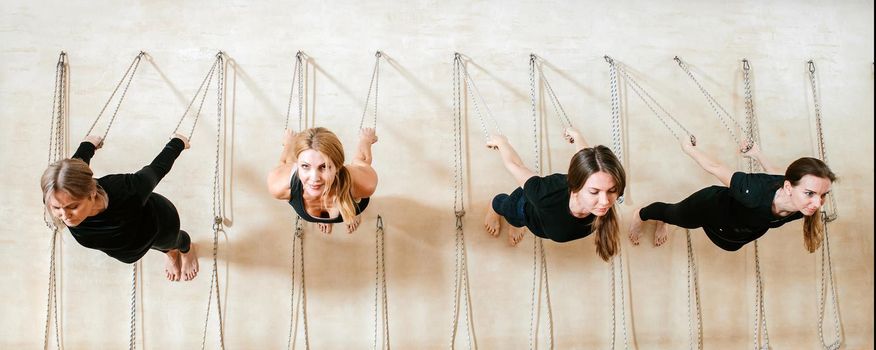 Iyengar female group of yogi practicing calisthenics exercise in a yoga studio