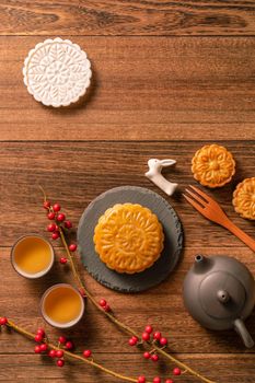 Creative Moon cake Mooncake table design - Chinese traditional pastry with tea cups on wooden background, Mid-Autumn Festival concept, top view, flat lay.