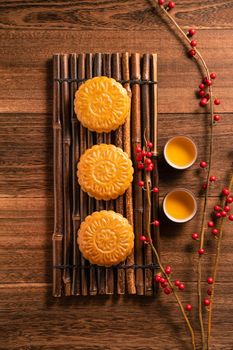 Moon cake Mooncake table setting - Chinese traditional pastry with tea cups on wooden background, Mid-Autumn Festival concept, top view, flat lay.