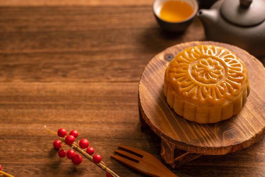 Moon cake Mooncake table setting - Round shaped Chinese traditional pastry with tea cups on wooden background, Mid-Autumn Festival concept, close up.