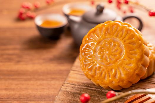 Moon cake Mooncake table setting - Round shaped Chinese traditional pastry with tea cups on wooden background, Mid-Autumn Festival concept, close up.