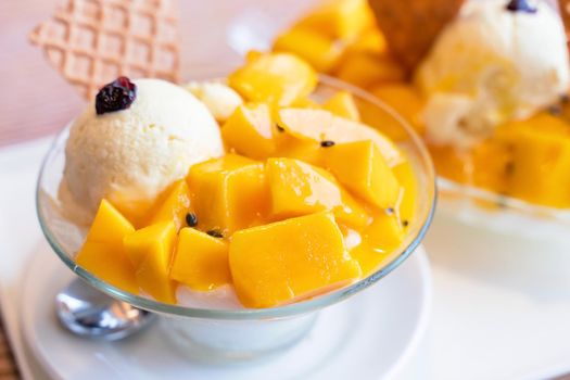 Fresh mango shaved ice with a scoop of ice cream and juice sauce in summer restaurant, lifestyle, popular food in Taiwan, close up.