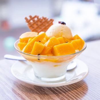 Fresh mango shaved ice with a scoop of ice cream and juice sauce in summer restaurant, lifestyle, popular food in Taiwan, close up.