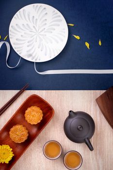 Creative Moon cake Mooncake design inspiration, enjoy the moon in Mid-Autumn festival with pastry and tea on wooden table concept, top view, flat lay
