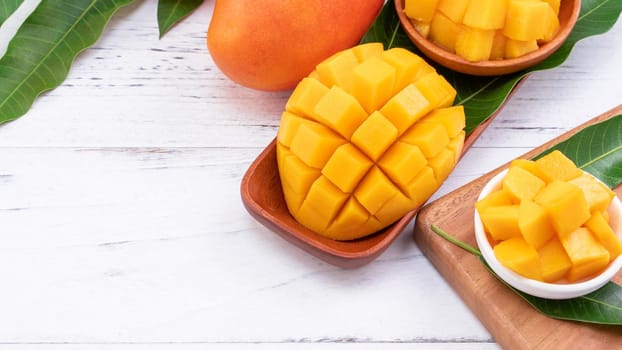 Fresh chopped mango on a tray and bright rustic wooden background. Tropical summer fruit design concept, close up, macro, copy space.