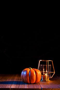 Halloween concept - Orange pumpkin lantern on a dark wooden table with black background, trick or treat, close up.