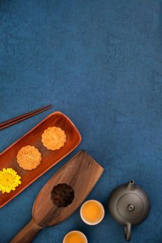 Minimal simplicity layout moon cakes on blue background for Mid-Autumn Festival, creative food design concept, top view, flat lay, copy space.