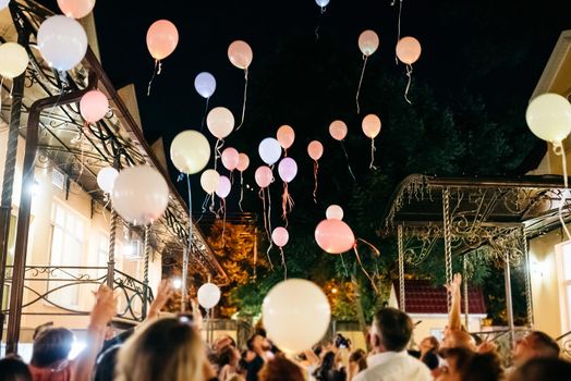Crowd Throwing Colorful Balloons to Sky at night During Festival or wedding