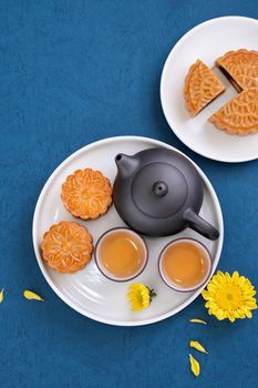 Minimal simplicity layout moon cakes on blue background for Mid-Autumn Festival, creative food design concept, top view, flat lay, copy space.