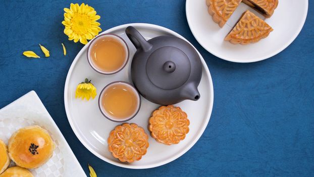 Minimal simplicity layout moon cakes on blue background for Mid-Autumn Festival, creative food design concept, top view, flat lay, copy space.