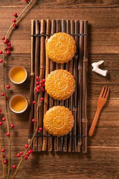 Creative Moon cake Mooncake table design - Chinese traditional pastry with tea cups on wooden background, Mid-Autumn Festival concept, top view, flat lay.
