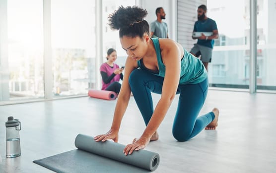 Yoga, studio and exercise mat with a fitness black woman getting ready for a wellness workout. Gym, training and zen with a female yogi indoor for mental health, balance or spiritual health.
