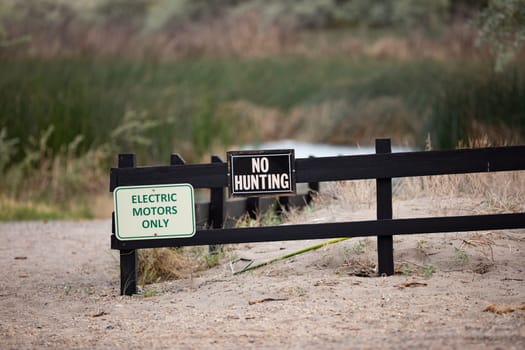 no hunting sign and electric motors only sign on a trail