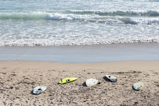 Surfboards on the beach by the sea. Mid shot