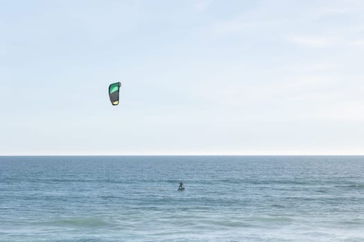 A person kitesurfing in the sea. Mid shot