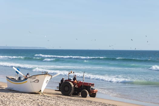 24 April 2023 Lisbon, Portugal: boat and tractor standing on the seashore - fishing. Mid shot